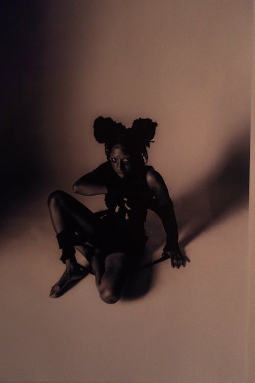 A black and white photo of a woman sitting on the ground