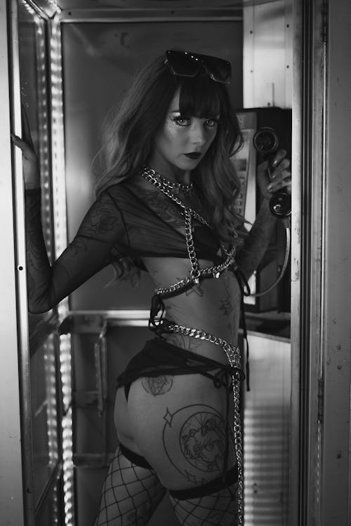 A woman in lingerie and fishnet stockings is standing in a locker