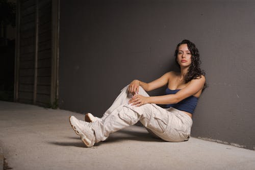 A woman sitting on the ground in a pair of pants