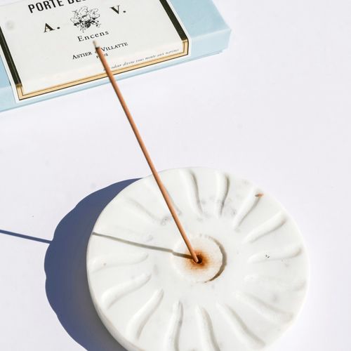 Free Close-up of a minimalist incense stick on a marble holder with soft shadows on a white background. Stock Photo