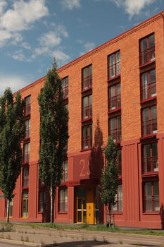 A modern low-rise brick apartment building with trees, located in Jönköping, Sweden.