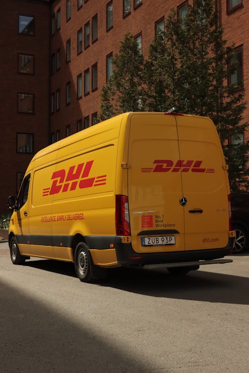 DHL Yellow Bus on Street in Sweden