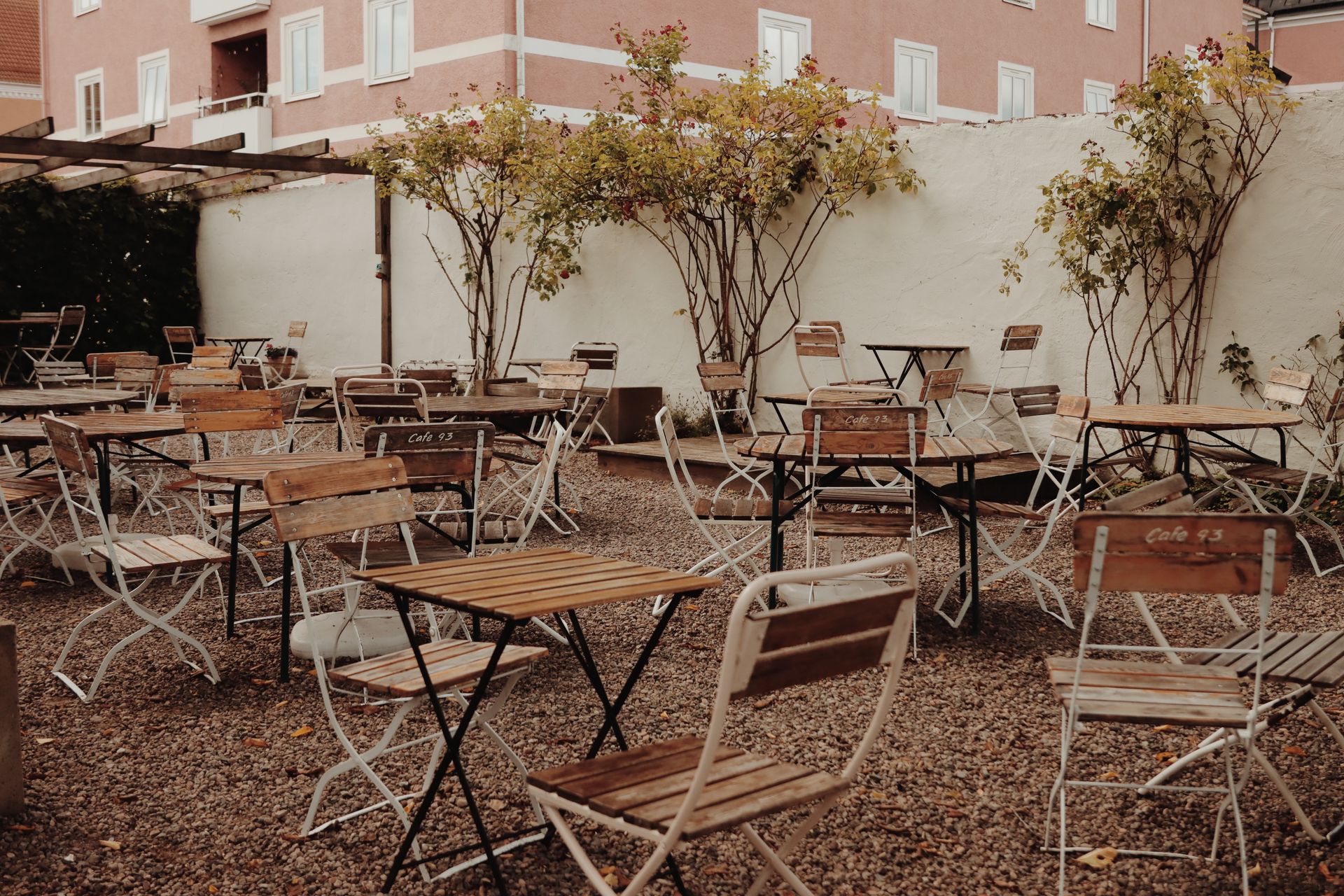 Empty patio at a café in Jönköping, Sweden, with rustic chairs and tables during fall.