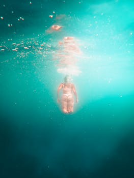 A person gracefully swimming underwater in the clear turquoise sea of Split, Croatia.