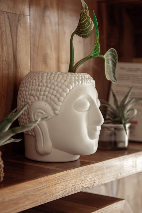 White Vase in Shape of Buddha on Shelf