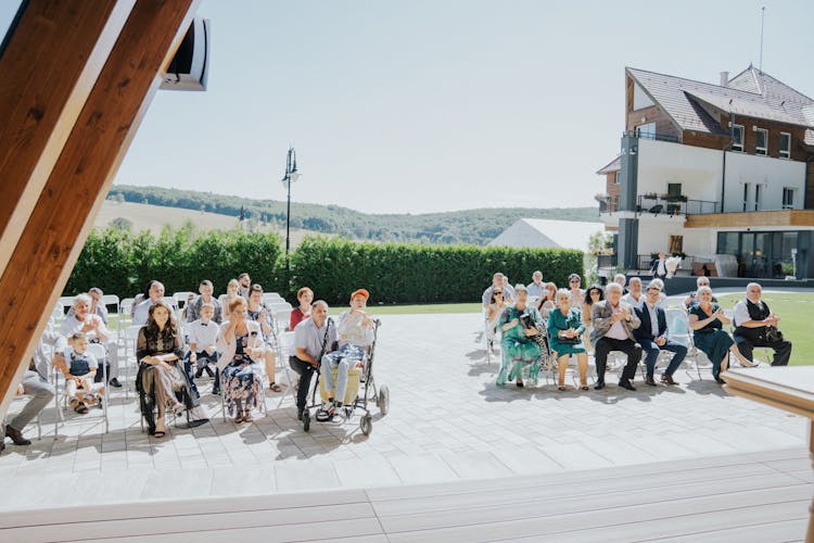 People Sitting On Ceremony On Sunlit Square