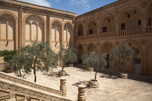 Free Explore the beautifully preserved historic courtyard in Mardin, Türkiye, showcasing stunning arches and stone architecture. Stock Photo