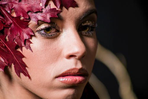 Close-up Studio Shot of a Young Woman Wearing a Decoration from Red Leaves on the Head
