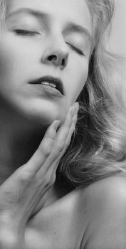 Close-up artistic black and white photo of a woman with eyes closed, exuding elegance.