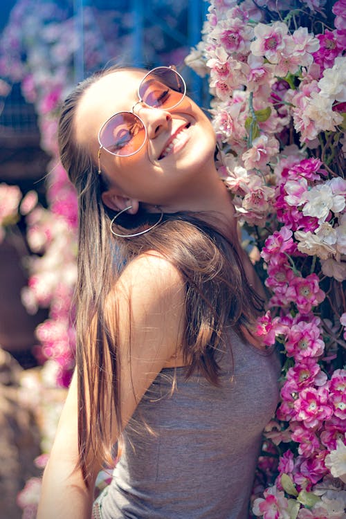 クラスターの花の横にあるタンクトップの女性