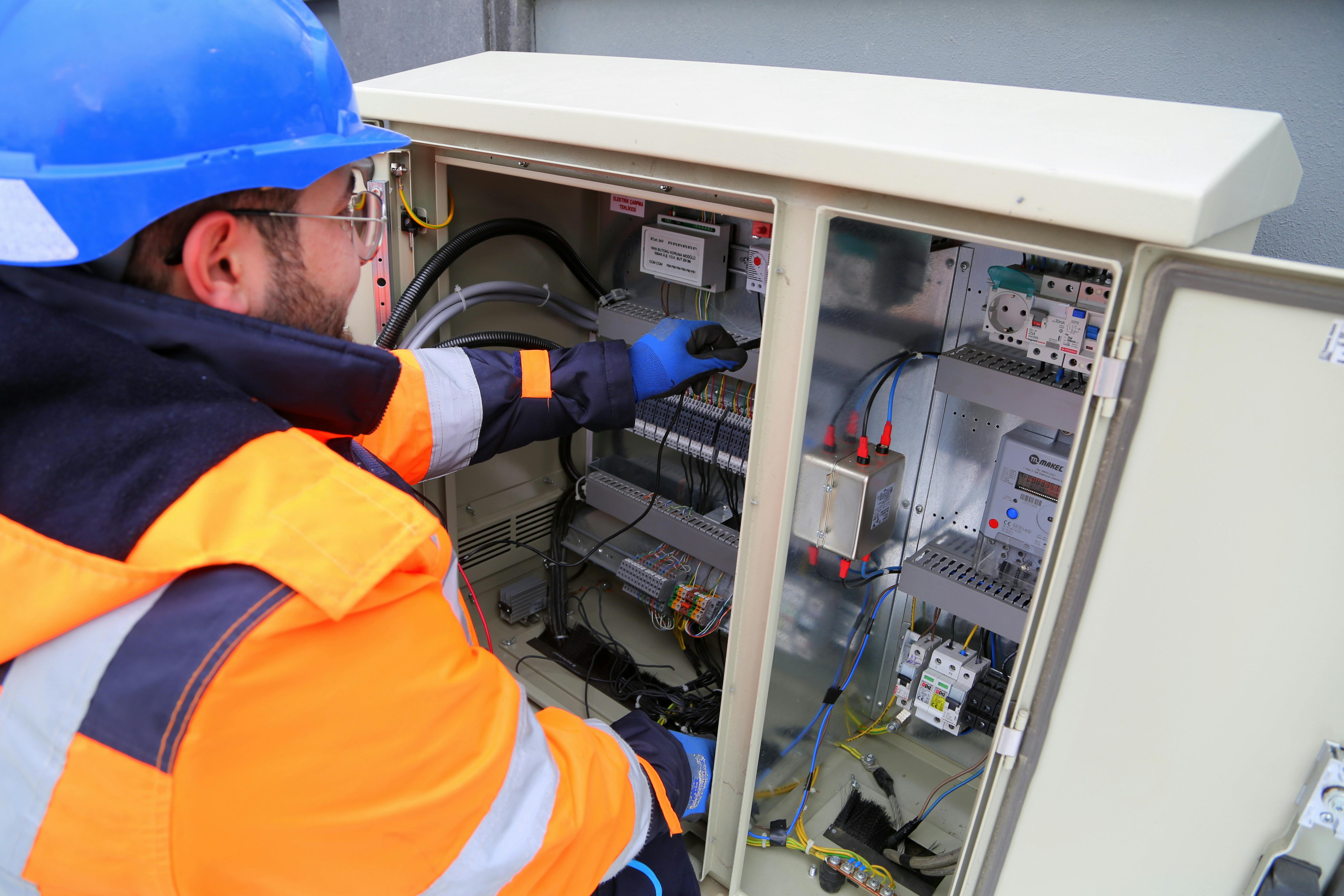 Image Name an electrician working in the fuse box
