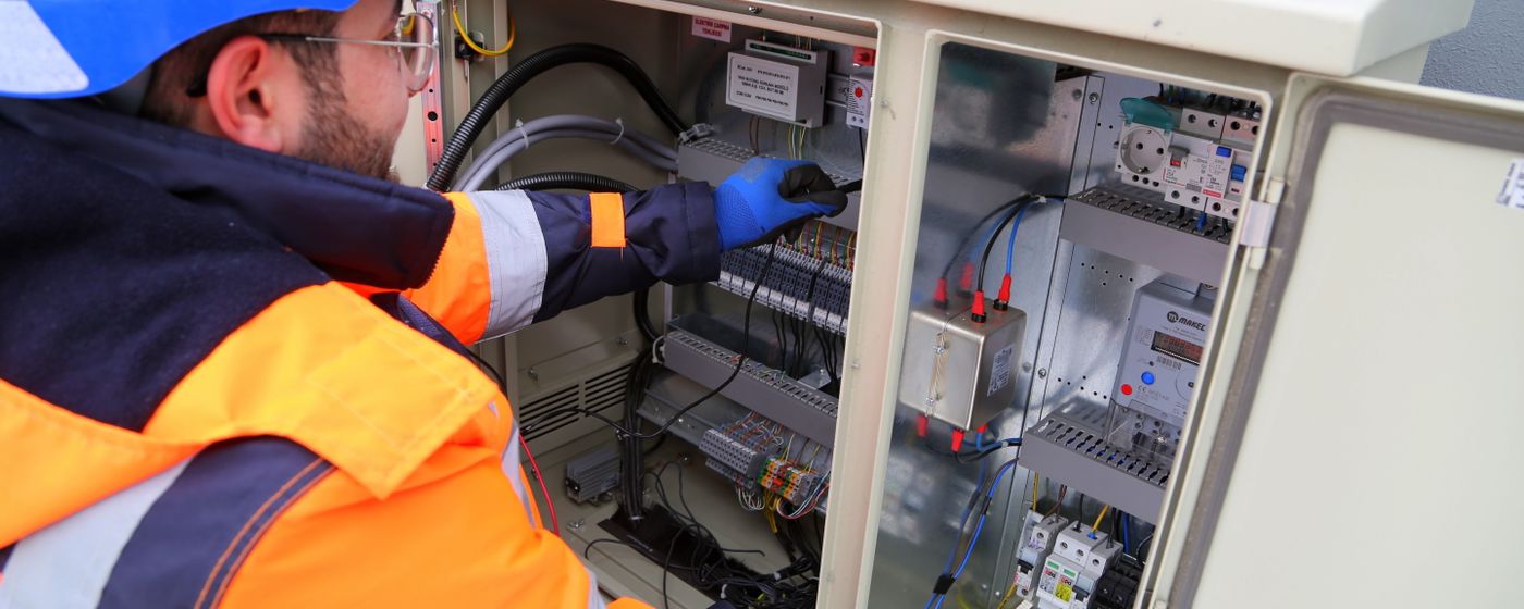 Field technician working on electrical panel