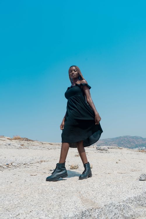 Free A stylish woman in a black dress posing in the desert landscape of Abuja, Nigeria. Stock Photo
