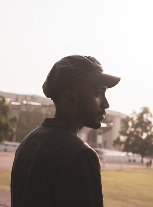 Free Portrait of a man wearing a flat cap in the sunlight, captured outdoors in Abuja, Nigeria. Stock Photo