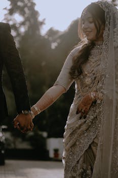 Beautiful Indian bride and groom holding hands during sunset in Edappal, Kerala.
