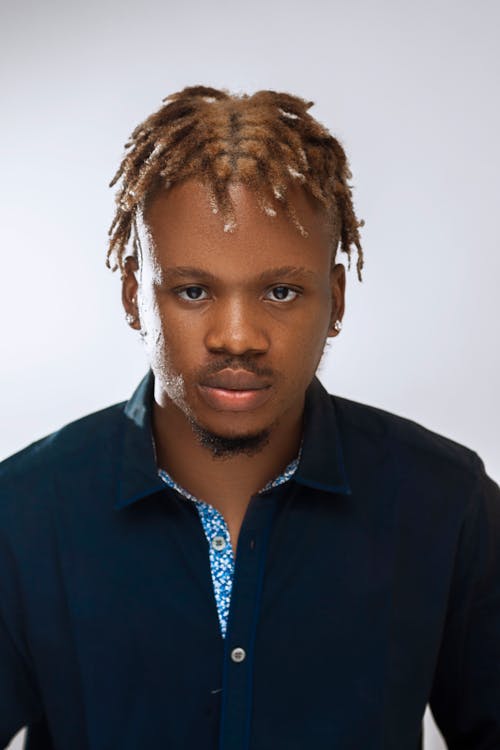 Young Man with Dyed Braids Posing in Blue Shirt