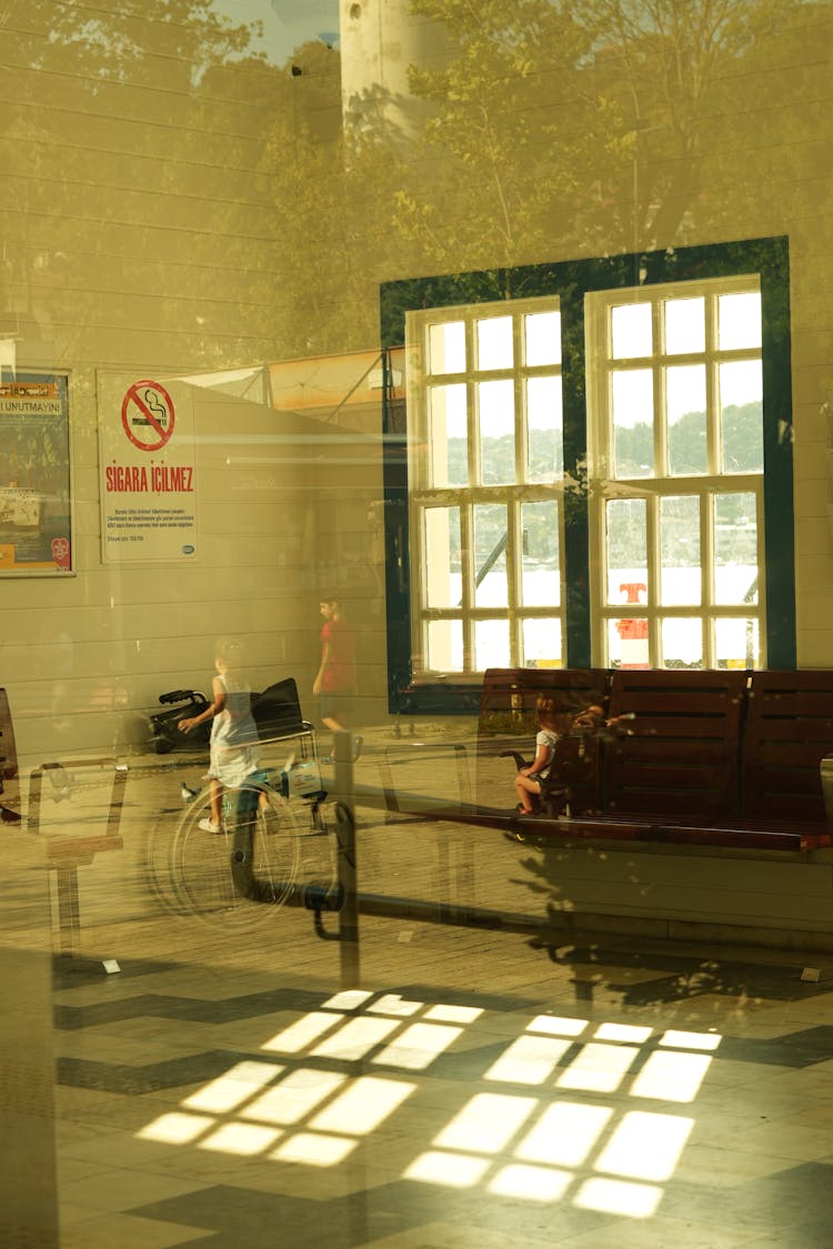 People Reflecting In Hospital Reception Ward Window