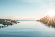 宁静的海景中，阳光照亮了平静的海水和岩石海岸线