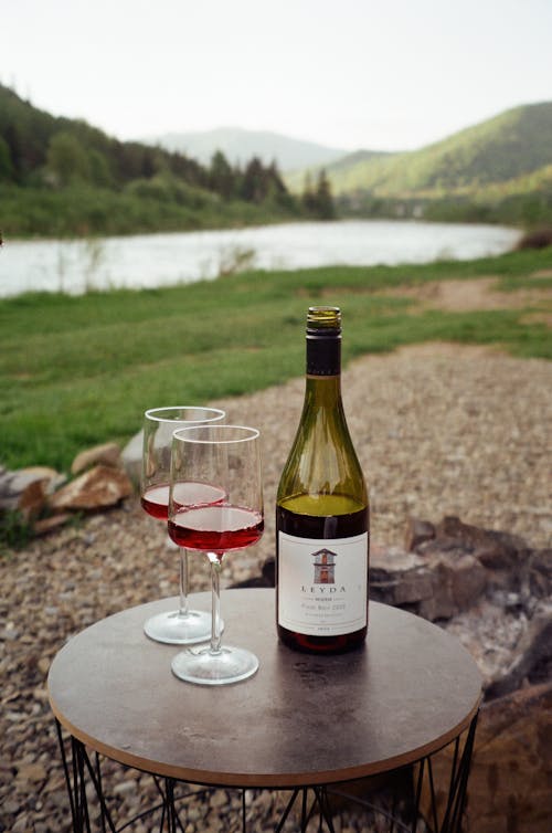 Glasses and a Bottle of Leyda Reserva Pinot Noir on a Table in a Valley by the River