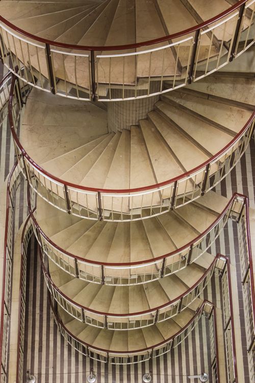 Free Capture of a spiral staircase with artistic design and modern architecture, offering a unique top-down perspective. Stock Photo