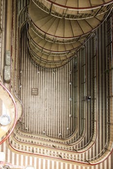 Aerial view of a modern, winding spiral staircase inside a building with intricate design.