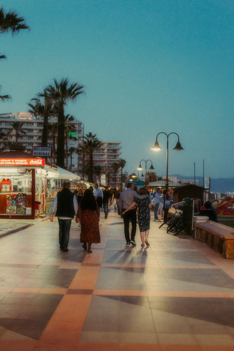 People Walking On Boardwalk In Evening 