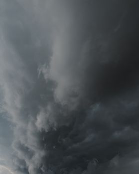A dramatic vertical shot of dark storm clouds filling the sky, suggesting an impending storm.. dramatic, vertical, shot