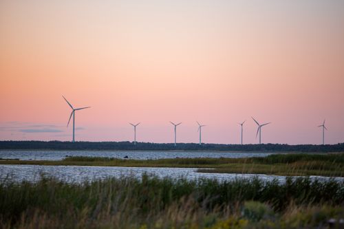Free Scenic view of wind turbines at sunset by a lake in Saaremaa, Estonia, showcasing renewable energy. Stock Photo