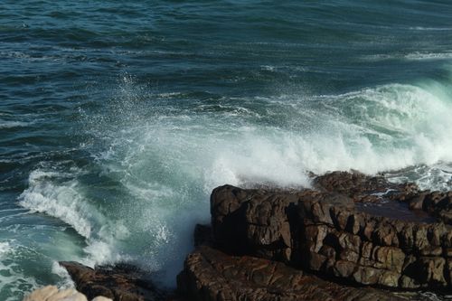 Free Powerful ocean waves crash against rugged rocks, showcasing nature's raw beauty and energy. Stock Photo