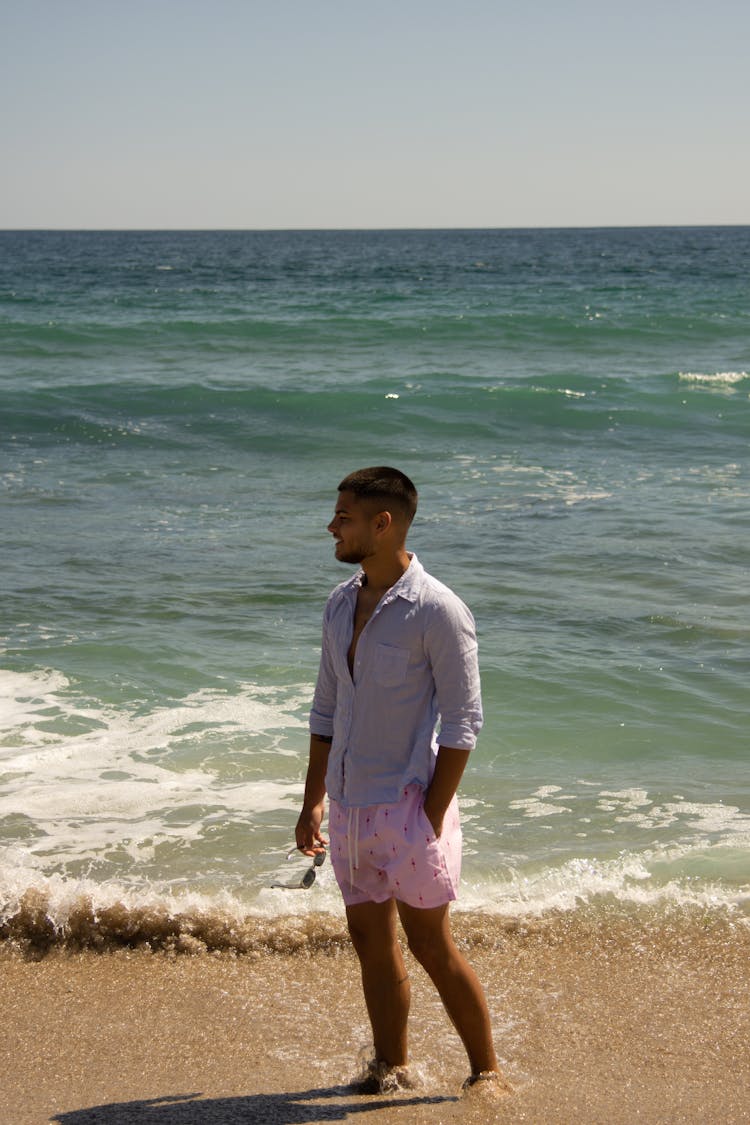 Young Man Standing On The Beach