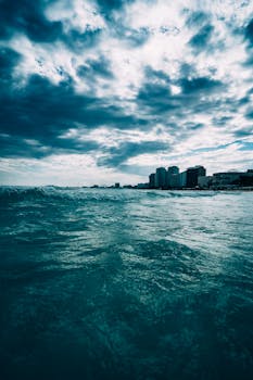 黄昏时分，海浪与现代建筑交相辉映，令人惊叹的海景中，天空云层引人注目