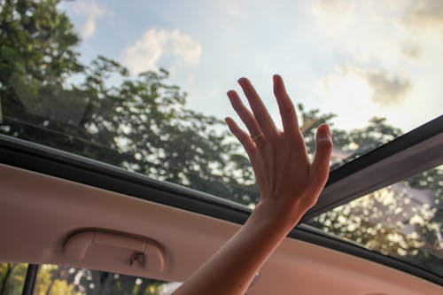 Person Touching Clear Glass Vehicle Sun Roof