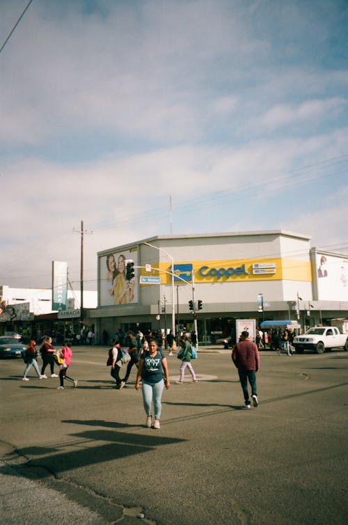 People Walking on a Street in Front of a Shop 