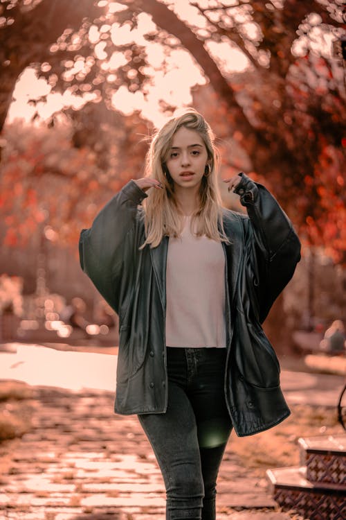Blonde Woman in Coat in Park in Autumn
