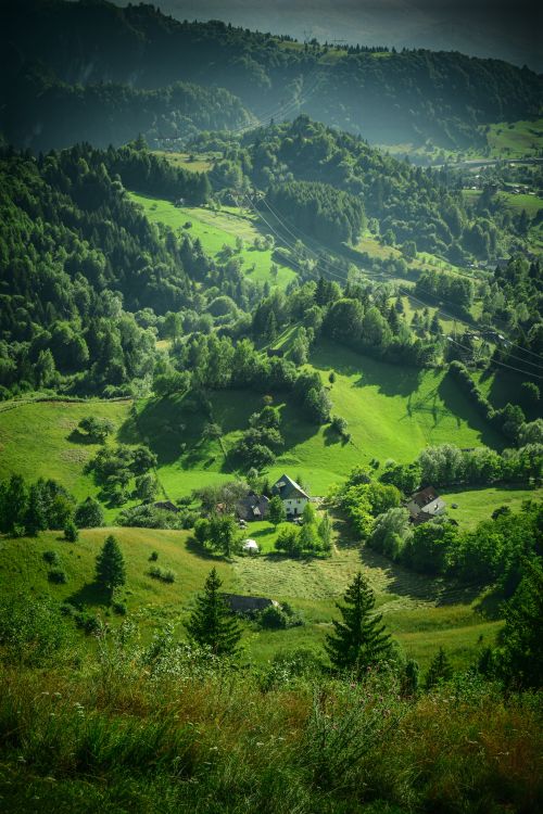 Free Scenic view of lush green hills and a remote village, perfect for nature lovers. Stock Photo