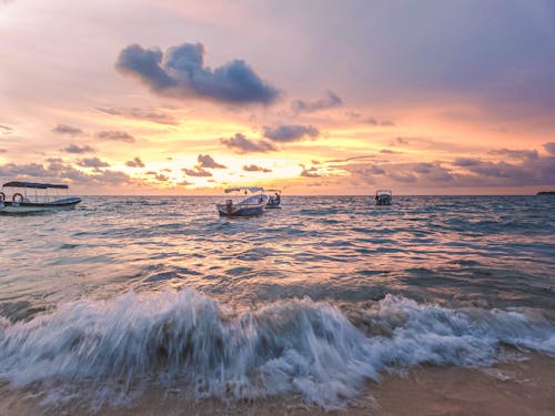 Boats in a Sea During Sunset 