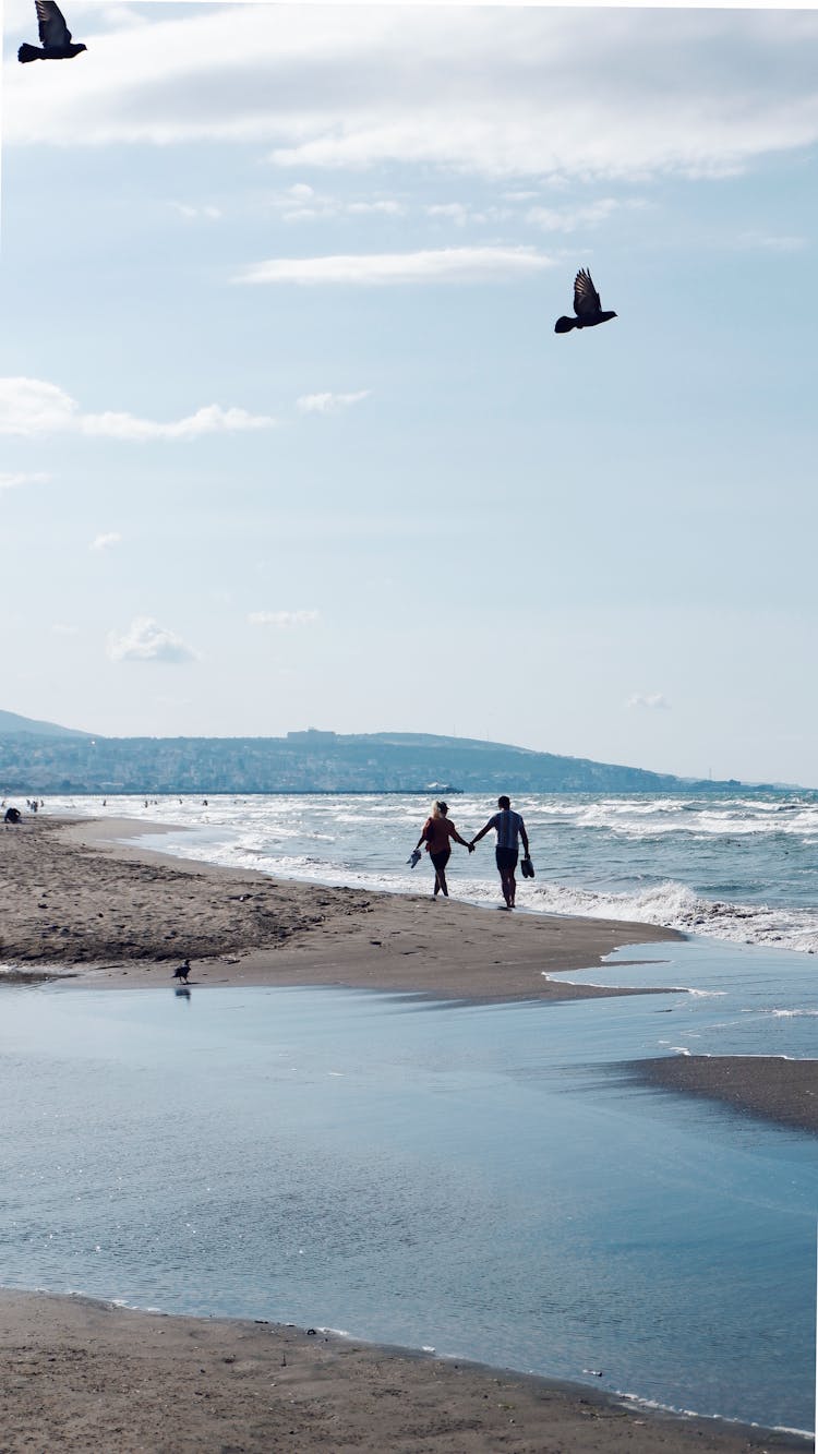 Couple Walking On Sea Shore