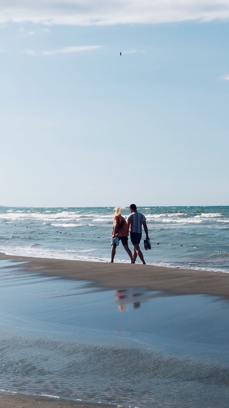 Couple Walking On Sand Beach