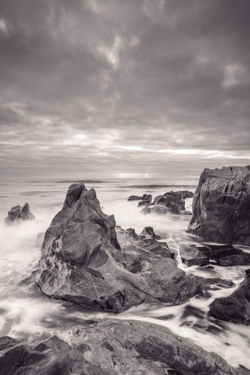Free A stunning view of rocky cliffs by the sea at sunrise in Vila Nova de Gaia, Portugal. Stock Photo