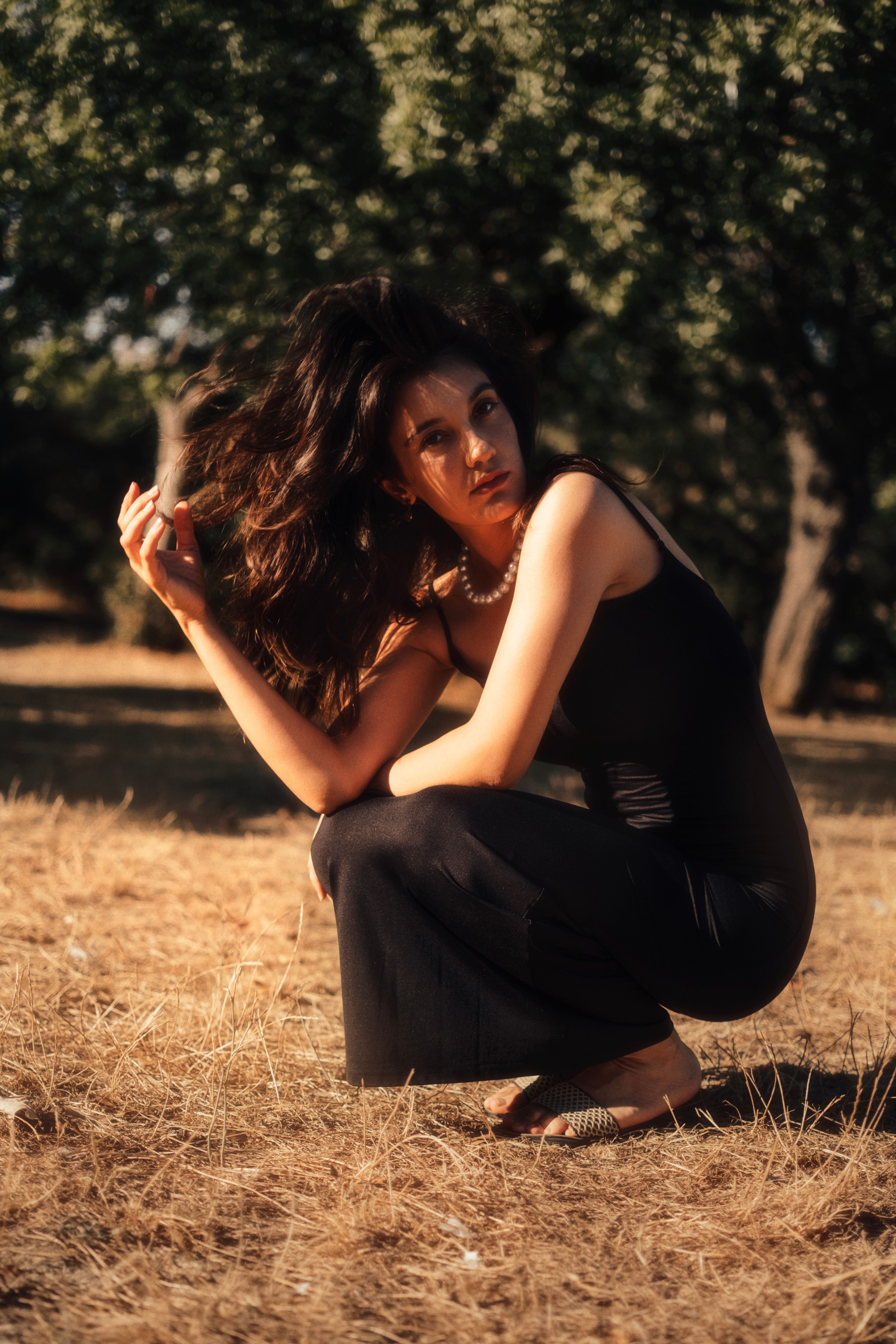 Beautiful Brunette Woman in Black Dress Posing in Park · Free Stock Photo