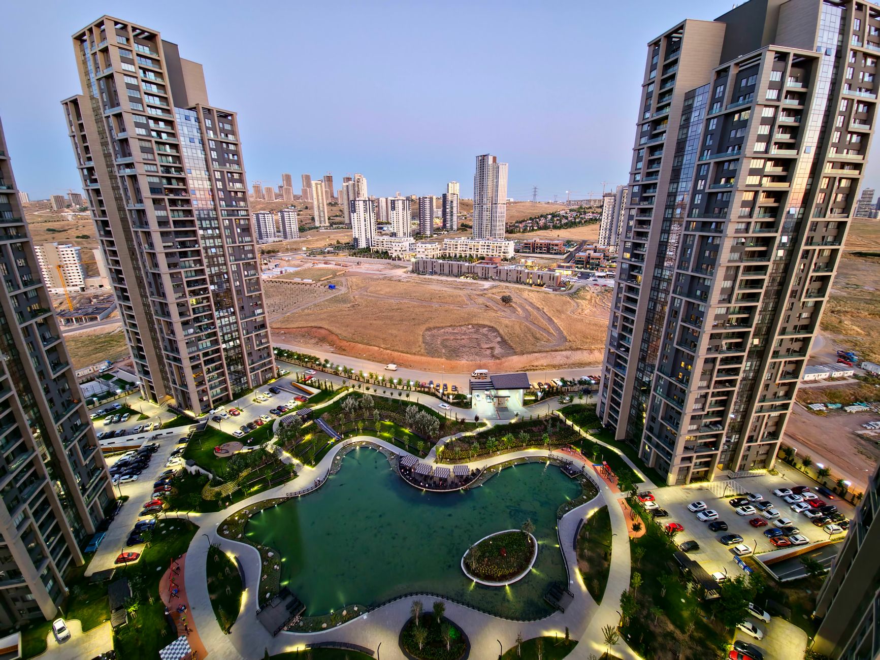 Drone shot capturing modern skyscrapers surrounding a pond in Ankara, Turkey.