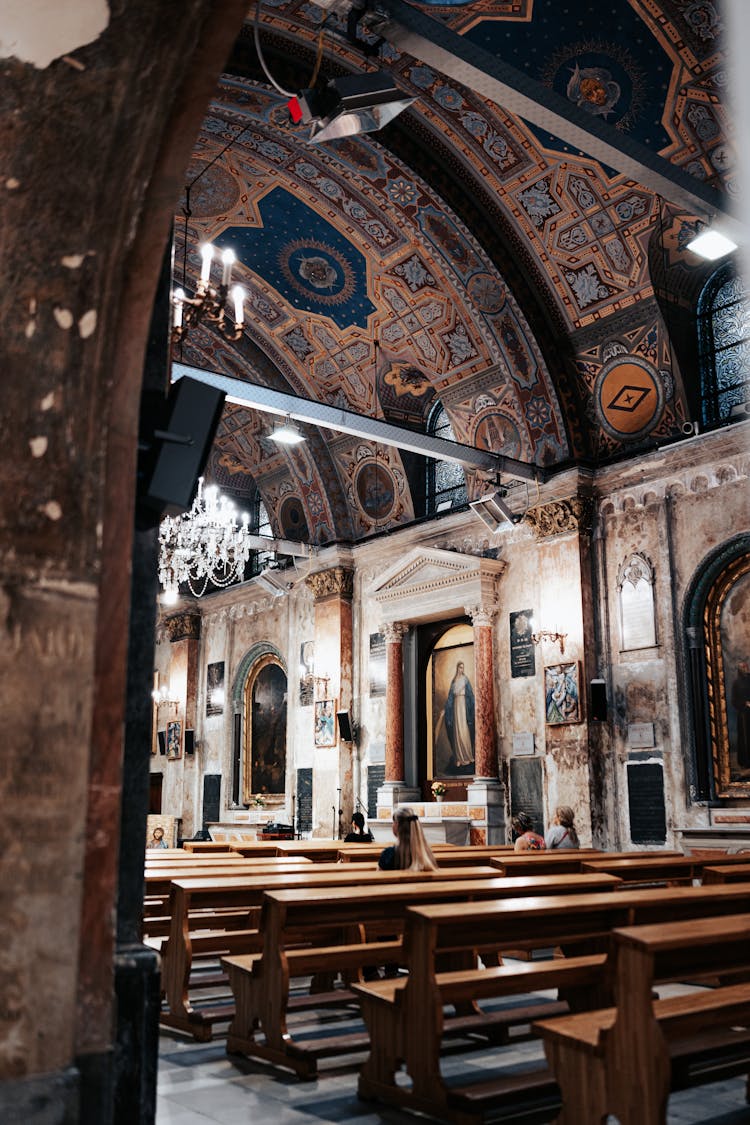 People Sitting On Benches In Ornate Church