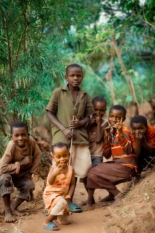 Free Joyful children posing together on a rural path surrounded by greenery in Bujumbura, Burundi. Stock Photo