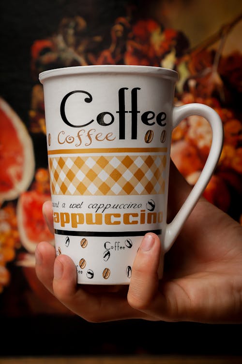A person holding a coffee mug with the words coffee on it