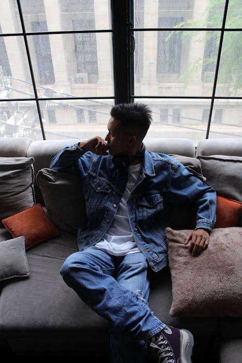 Man Sitting and Posing on Couch near Windows