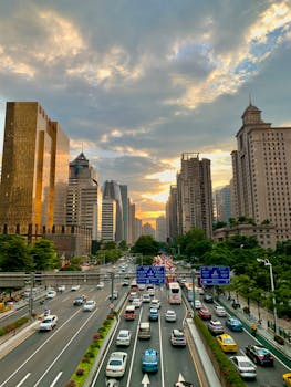 Dynamic view of the Guangzhou cityscape with bustling traffic and towering skyscrapers against a sunset sky.