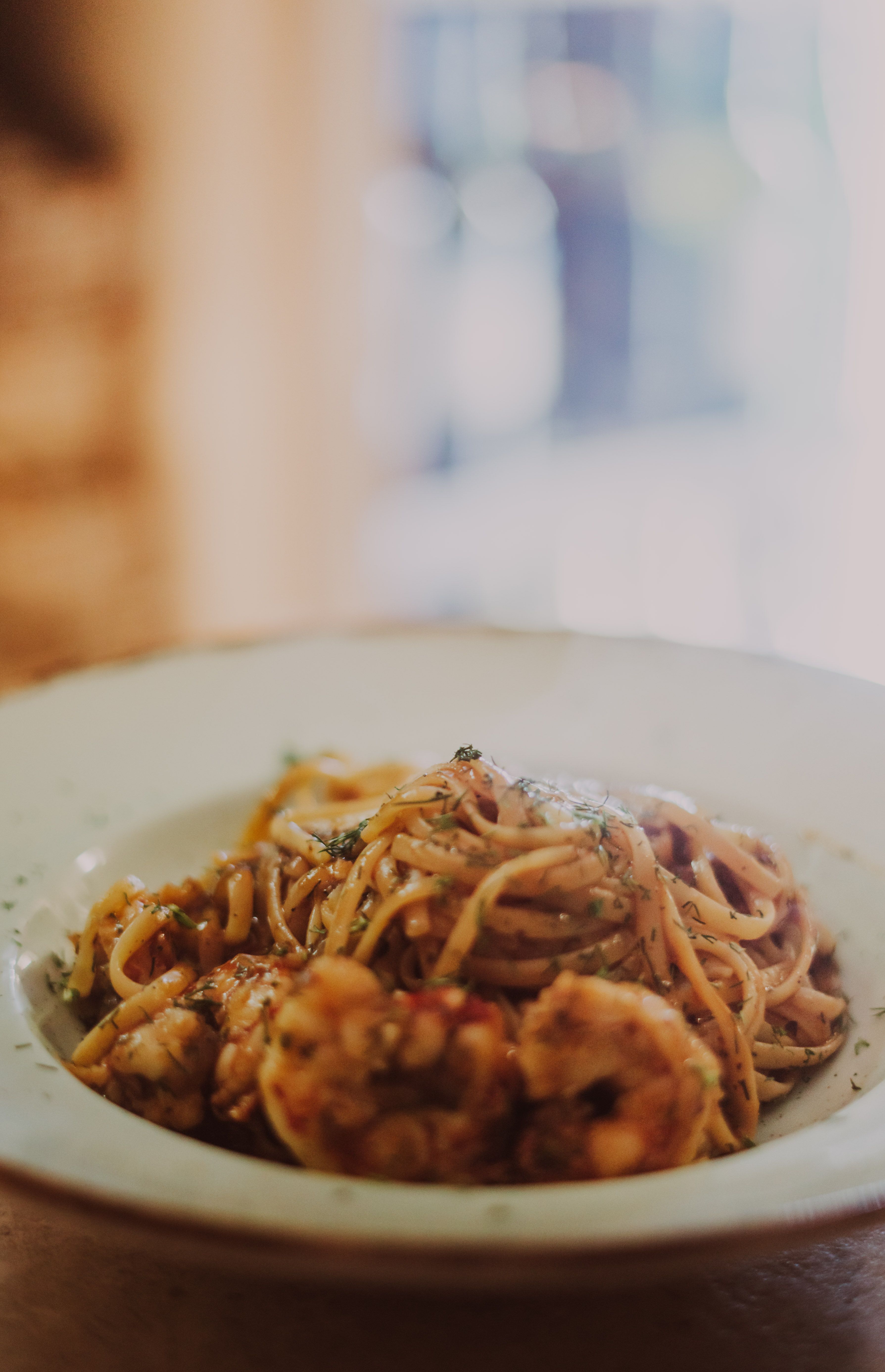 A mouthwatering shrimp pasta served on a white plate with artistic presentation.