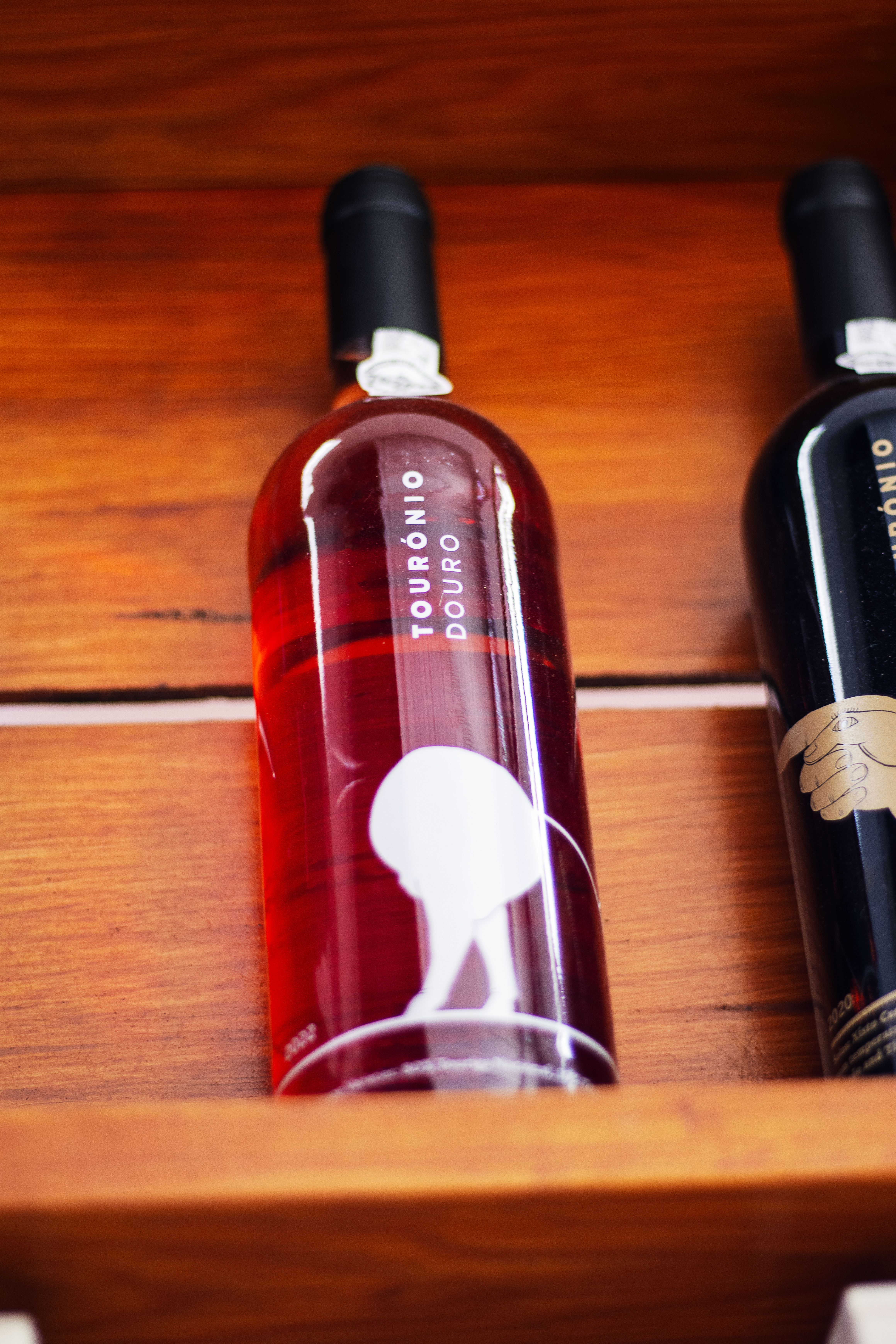 Wine bottles displayed on a wooden shelf, highlighting a rustic and elegant design.
