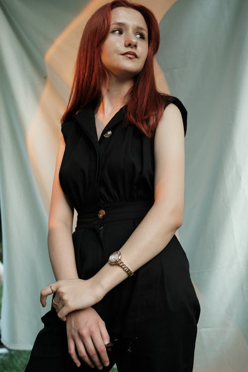 Young Woman Posing in a Black Outfit on the Background of a White Sheet 