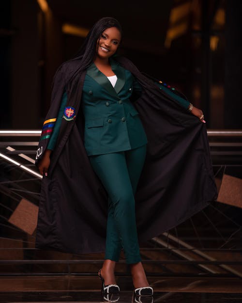 Young Elegant Woman Wearing a Graduation Gown and Smiling 